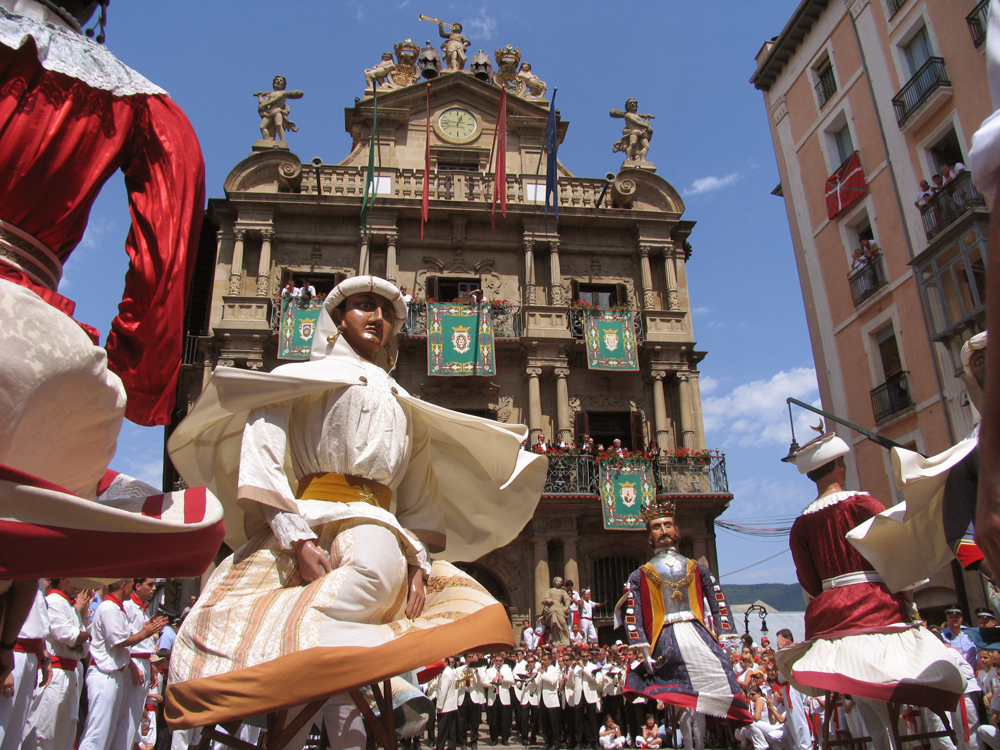 Gigantes y cabezudos bailando en una calle de Pamplona durante un pasacalles festivo